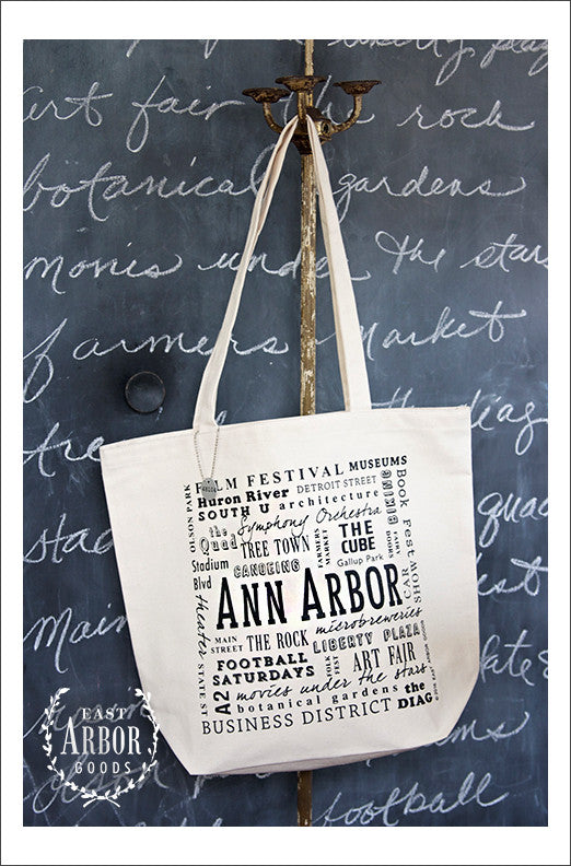 Large natural colored canvas tote bag featuring Ann Arbor, Michigan. Words in different fonts and sizes showcase local places and activities.