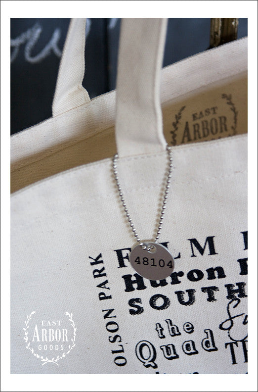 Close Up View Of Small Metal Tag With Ann Arbor Zip Code 48104 close-up-view-of-small-metal-tag-with-ann-arbor-zip-code-48104