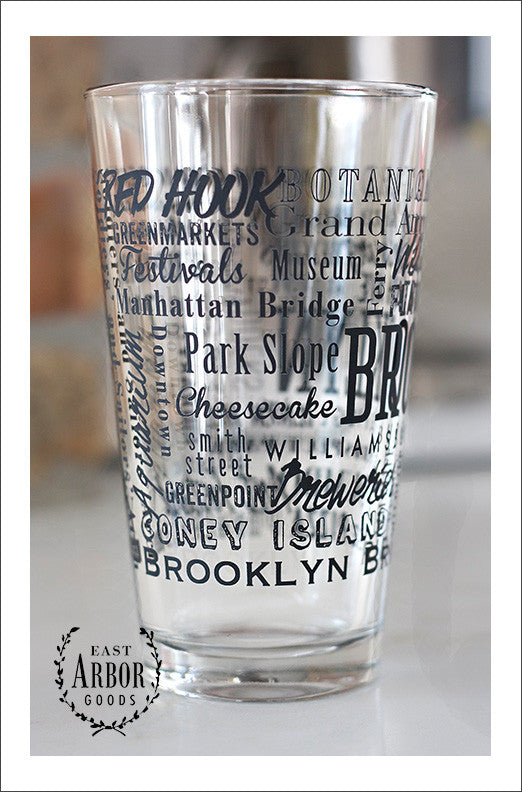 Left side view of Pint Glass featuring Brooklyn, New York with highlights from the town in black screen print.