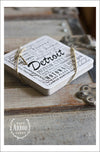 A set of drink coasters wrapped in twine shown featuring Detroit, Michigan. Each set comes with 6 thick cardstock coasters with black screen print. 