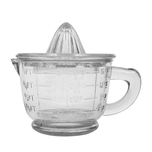 Close up of vintage farm-house thick-glass two-piece juicer set with a two cup measuring cup with handle and spout topped with a glass citrus juicer.