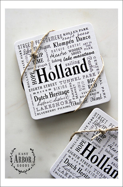 Two sets of drink coasters each tied with decorative twine shown featuring Holland, Michigan. Each set comes with 6 thick cardstock coasters with words in different fonts and sizes in black screen print. 