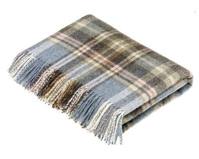 Folded wool blanket throw with colors of lake blue and a mix of tans and taupes. Edge of blanket has tassles in the same colors. 